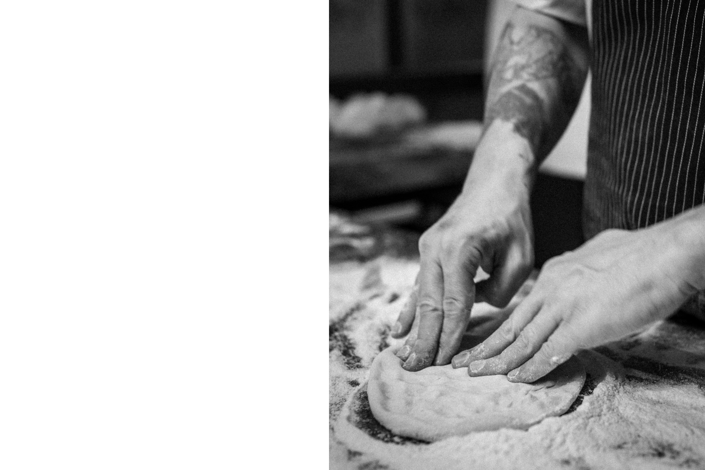 Hands kneeding dough to make pizza.